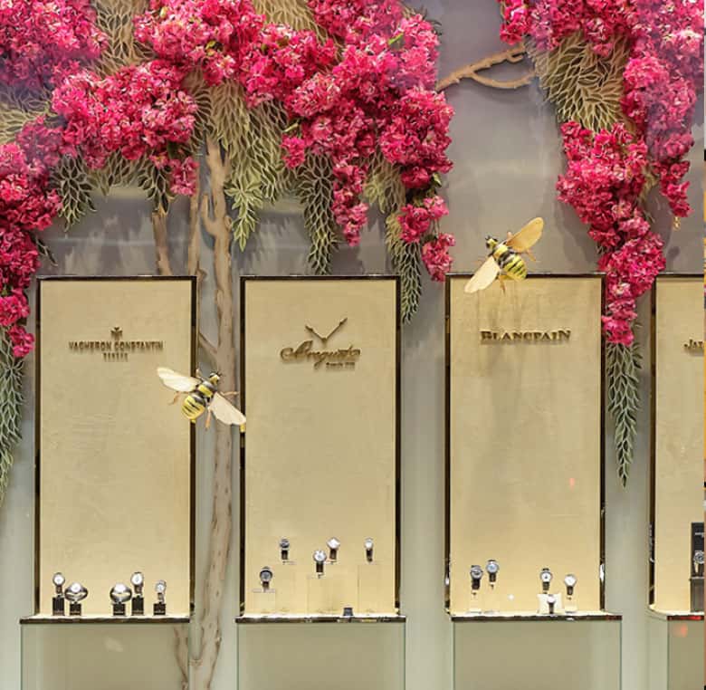 Escaparate de una joyería Rabat con flores rosas y expositores con joyas