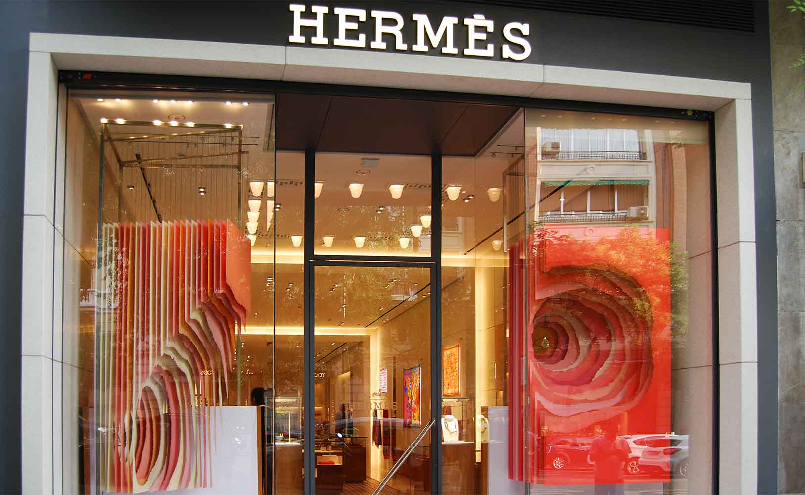 Un escaparate lateral y otro frontal con distintas tonalidades y colores para Hermès