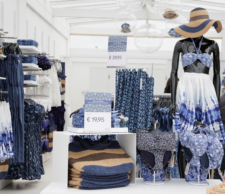 Tienda temporal de H&M junto al mar, con arquitectura funcional y tonos neutros para destacar su colección de verano.