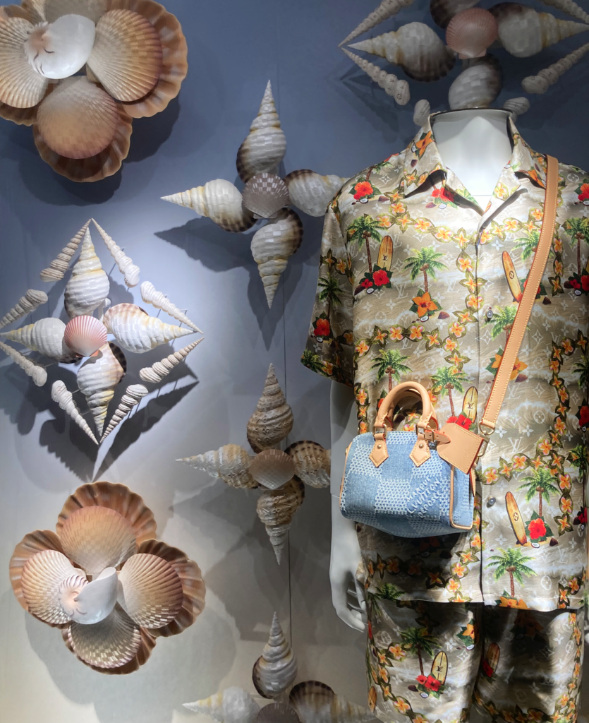 Escaparate de Louis Vuitton con diseño marino, con grandes conchas que envuelven bolsos y accesorios de la colección verano.
